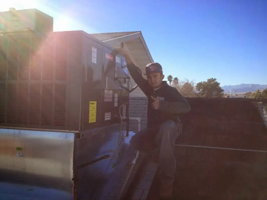 HVAC technician performing AC Tune-Up on a rooftop unit in Essex